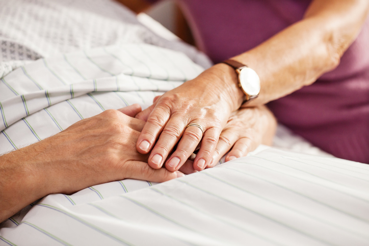 Senior patient holding his wifes hand